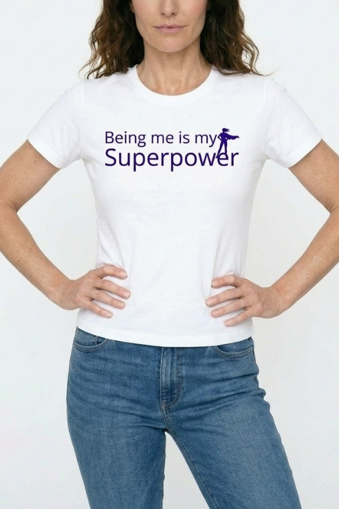 Person wearing a white t-shirt with 'Being me is my Superpower' text and graphic on a plain background