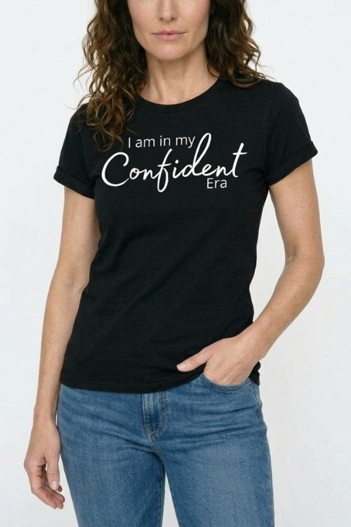 Person wearing a black t-shirt with 'I am in my Confident Era' text on a white background