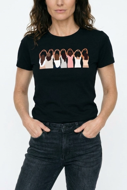 Person wearing a black t-shirt with a graphic of diverse women on a white background