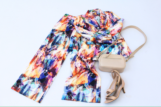 Colorful suit, beige handbag, and high-heeled shoes on a light blue background