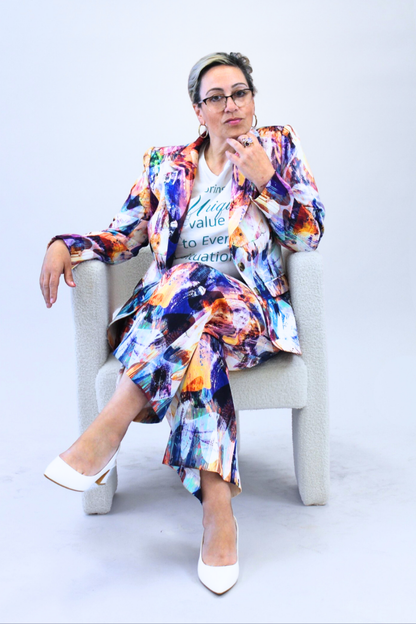 Woman sitting on a chair wearing a colorful outfit with a white background