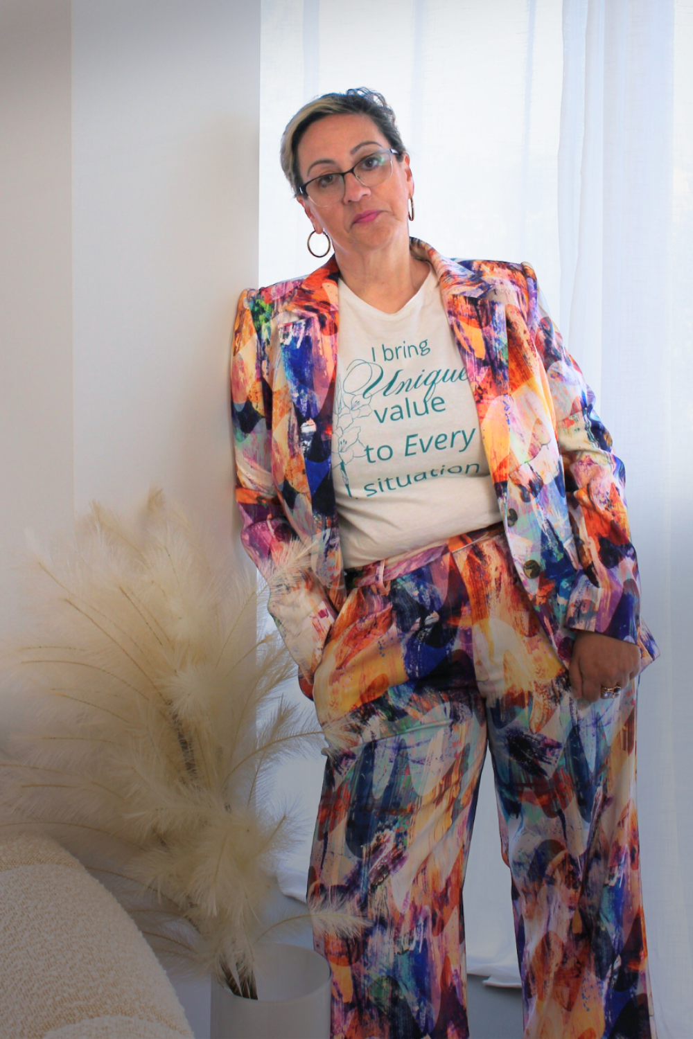 Person wearing a colorful suit with a white t-shirt underneath, standing against a neutral background.