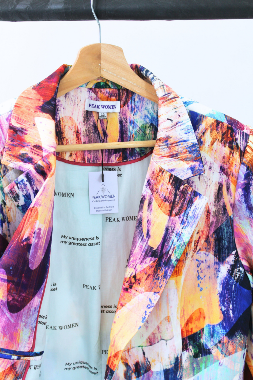 Colorful jacket on a hanger with a visible brand tag against a white background