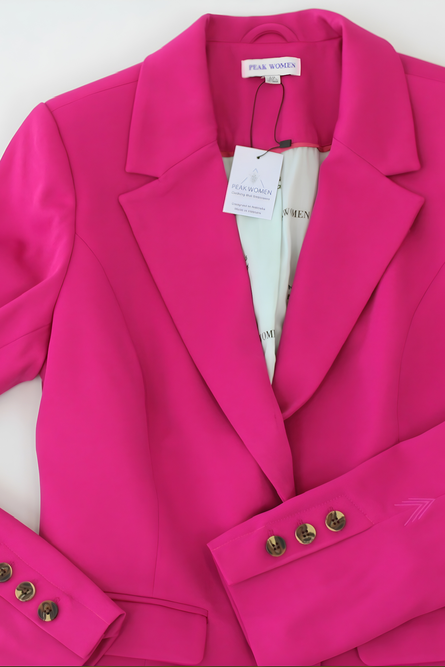 Pink blazer with gold buttons on a white background