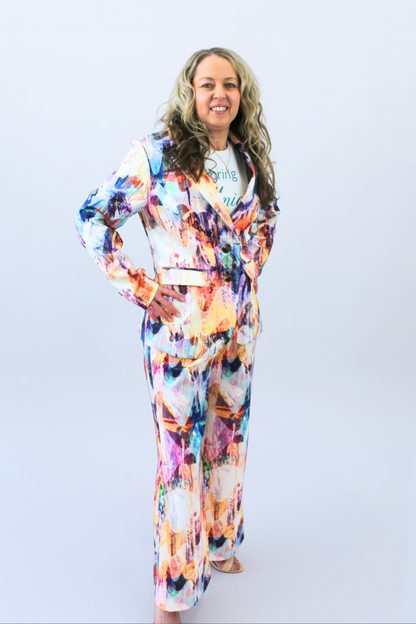 Woman wearing a colorful outfit with a white background hands on hips