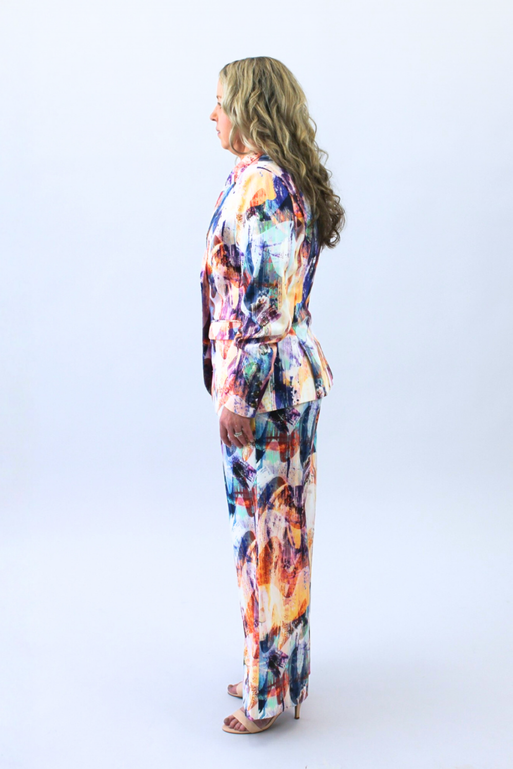 Woman wearing a colorful suit on a white background looking at the left side