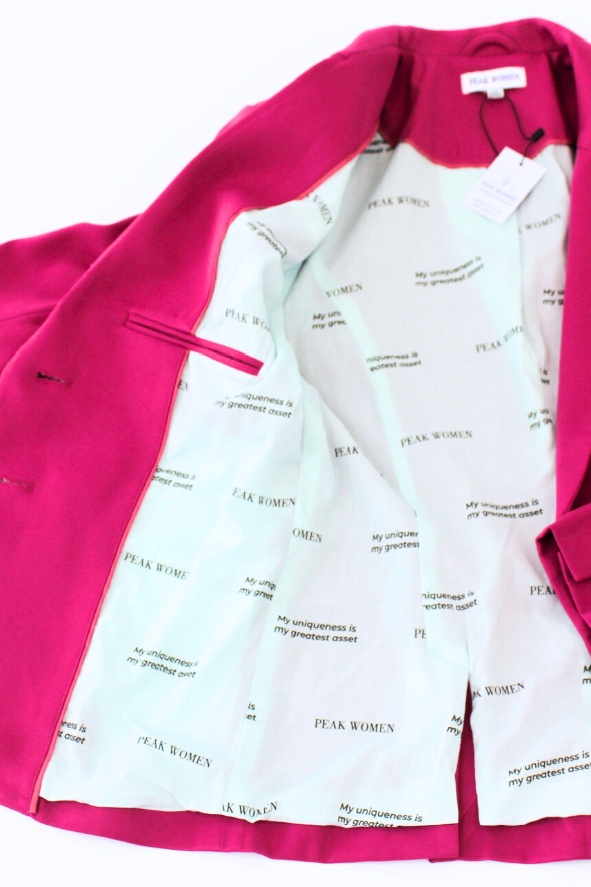Pink blazer over a white shirt with text on a white background