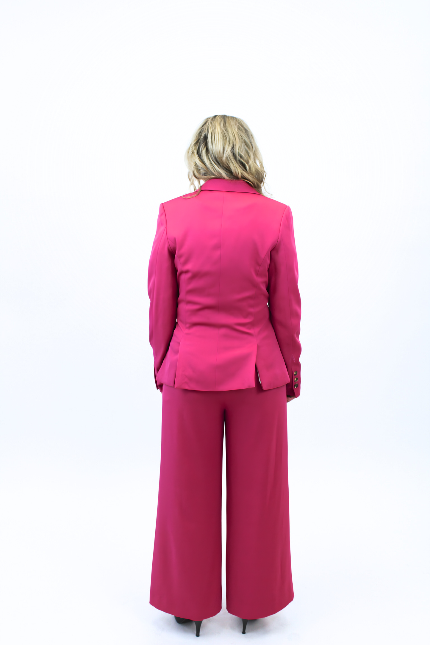 Person wearing a bright pink suit on a white background