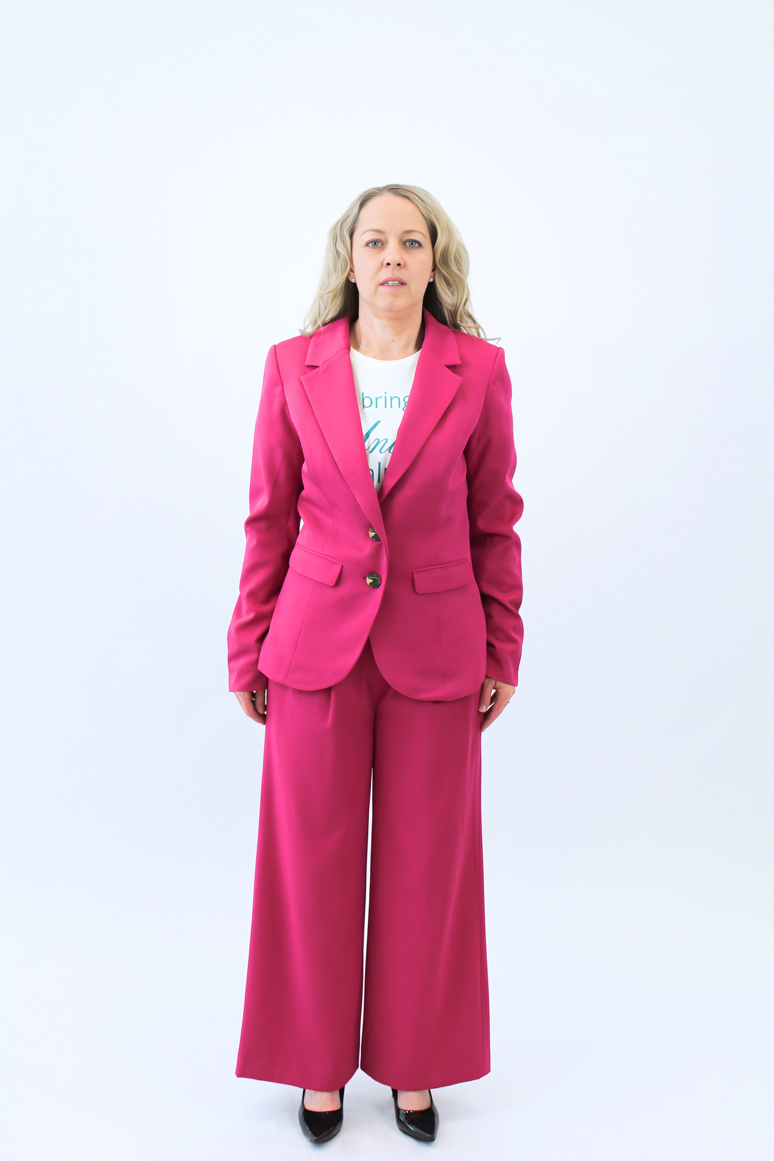 Woman wearing a bright pink suit on a white background