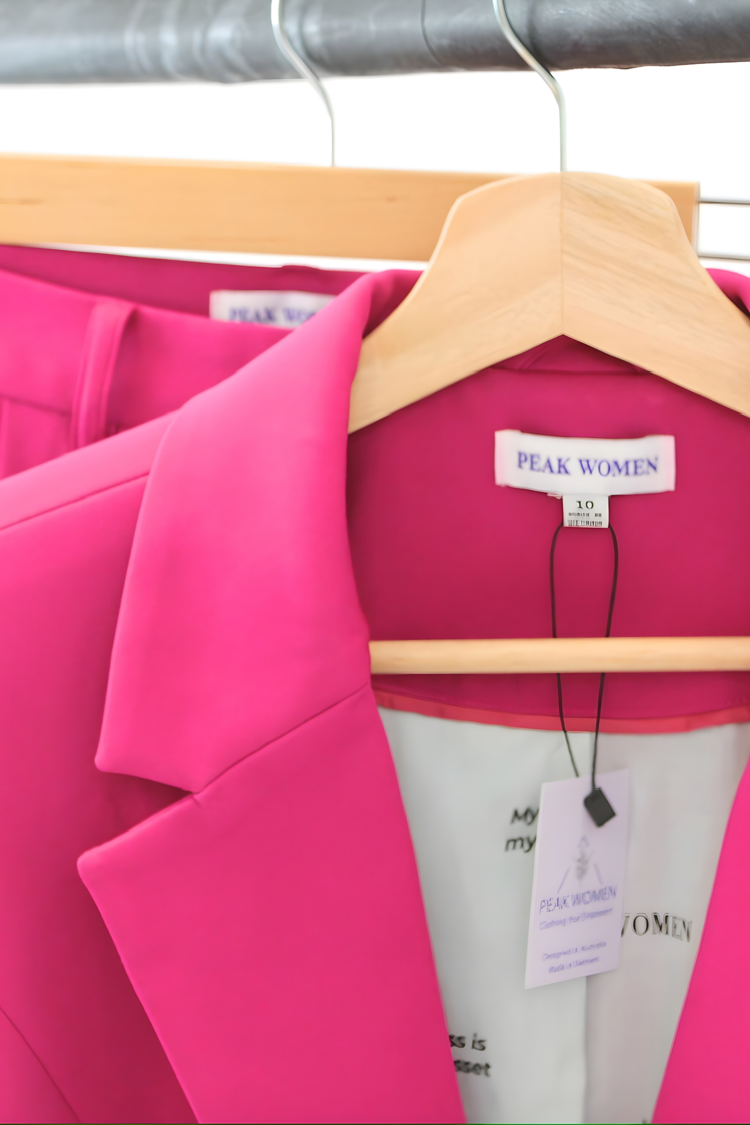 Pink blazer on a hanger with 'Peak Women' label