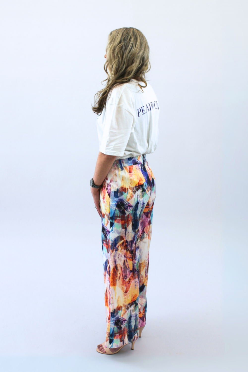 Person wearing a white t-shirt and colorful pants on a white background