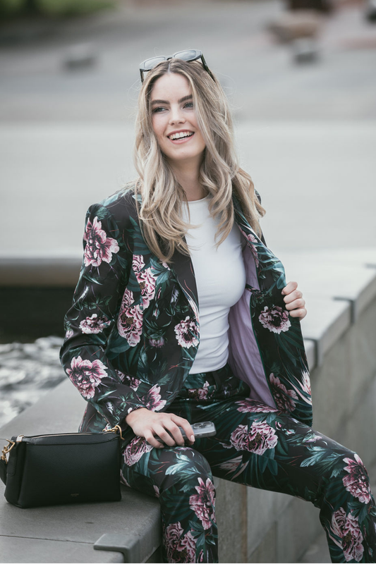Woman wearing a floral suit sitting outdoors