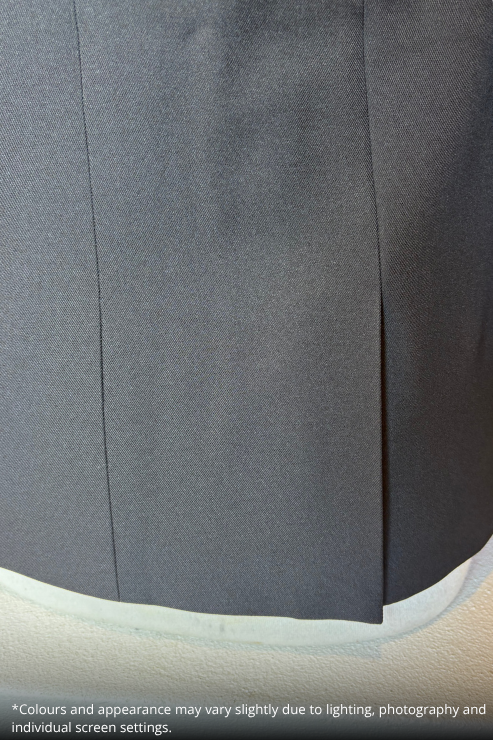 Close-up of a black textured fabric garment, showing a vertical seam and a curved hem, with a small white text disclaimer at the bottom.