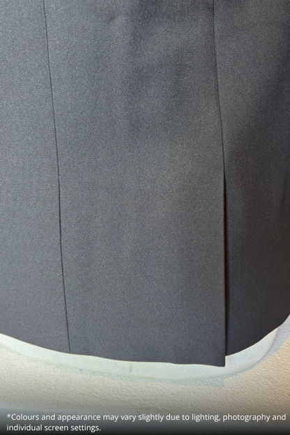 Close-up of a black textured fabric garment, showing a vertical seam and a curved hem, with a small white text disclaimer at the bottom.