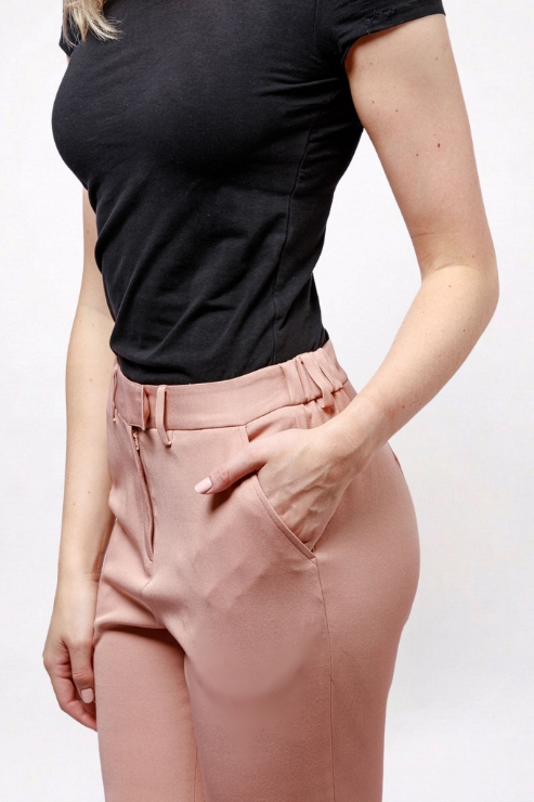 A model wearing high-waisted dusty rose trousers with a belt and side pockets, paired with a black t-shirt, shown from the chest down against a plain white background.
