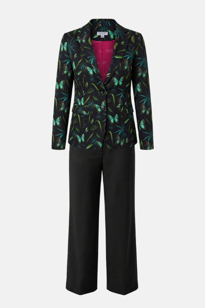A women's two-piece suit featuring a black blazer with a vibrant green and blue butterfly pattern and a bright magenta lining, paired with solid black wide-leg trousers, shown on a light gray background.