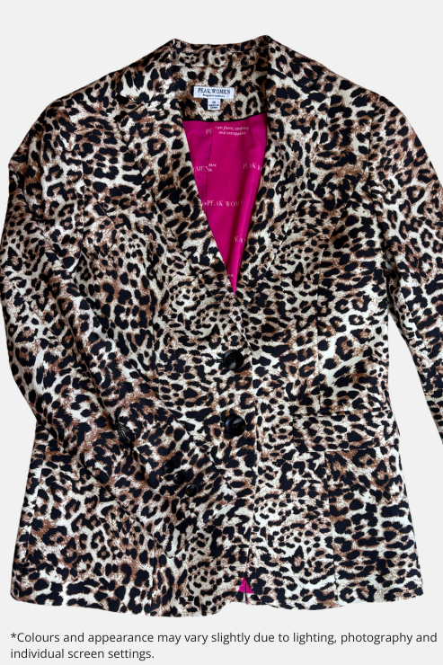A leopard print blazer with a vibrant pink lining, laid flat on a speckled beige countertop.
