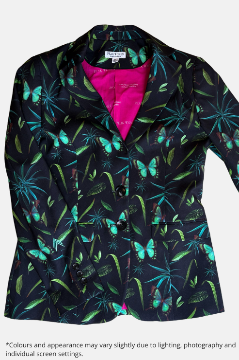 A women's blazer jacket with a black base, featuring a vibrant tropical print of green palm leaves and turquoise butterflies. The interior lining is a bright hot pink.